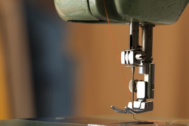 Photo of Vintage sewing machine with thread on blurred background, macro view. Space for text