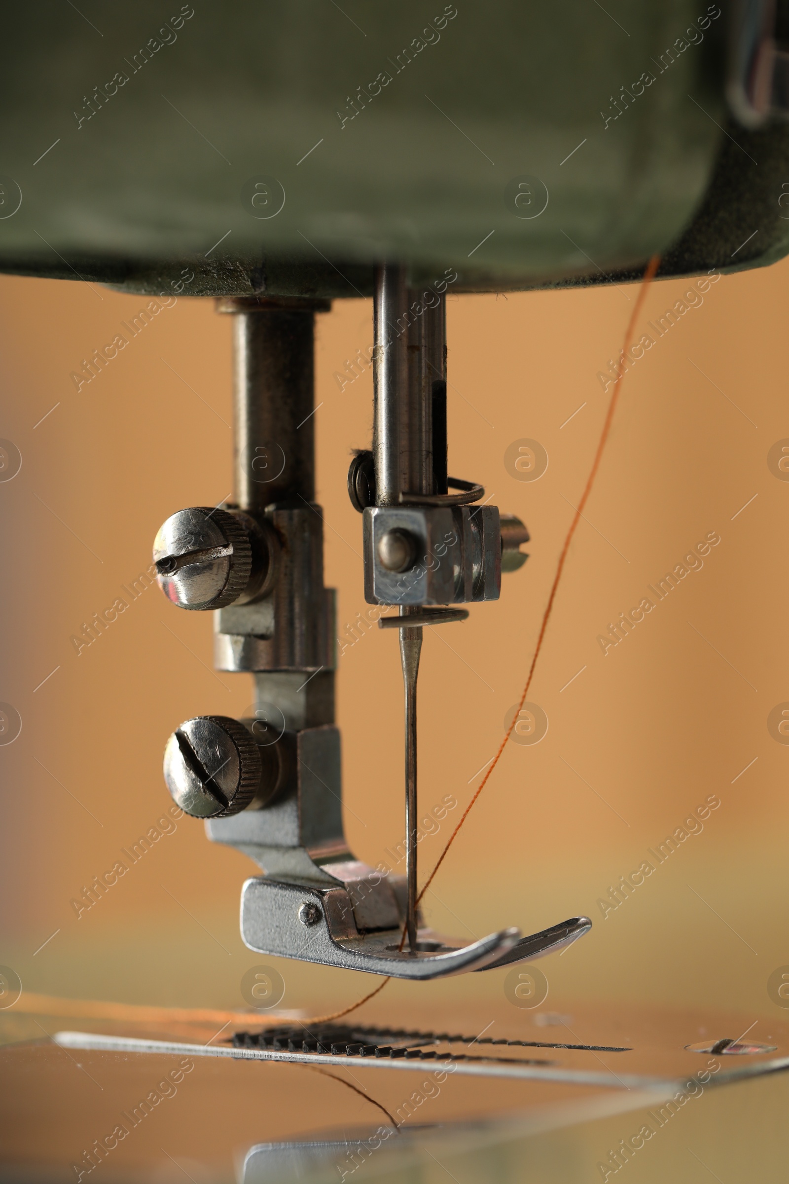 Photo of Vintage sewing machine with thread on blurred background, macro view