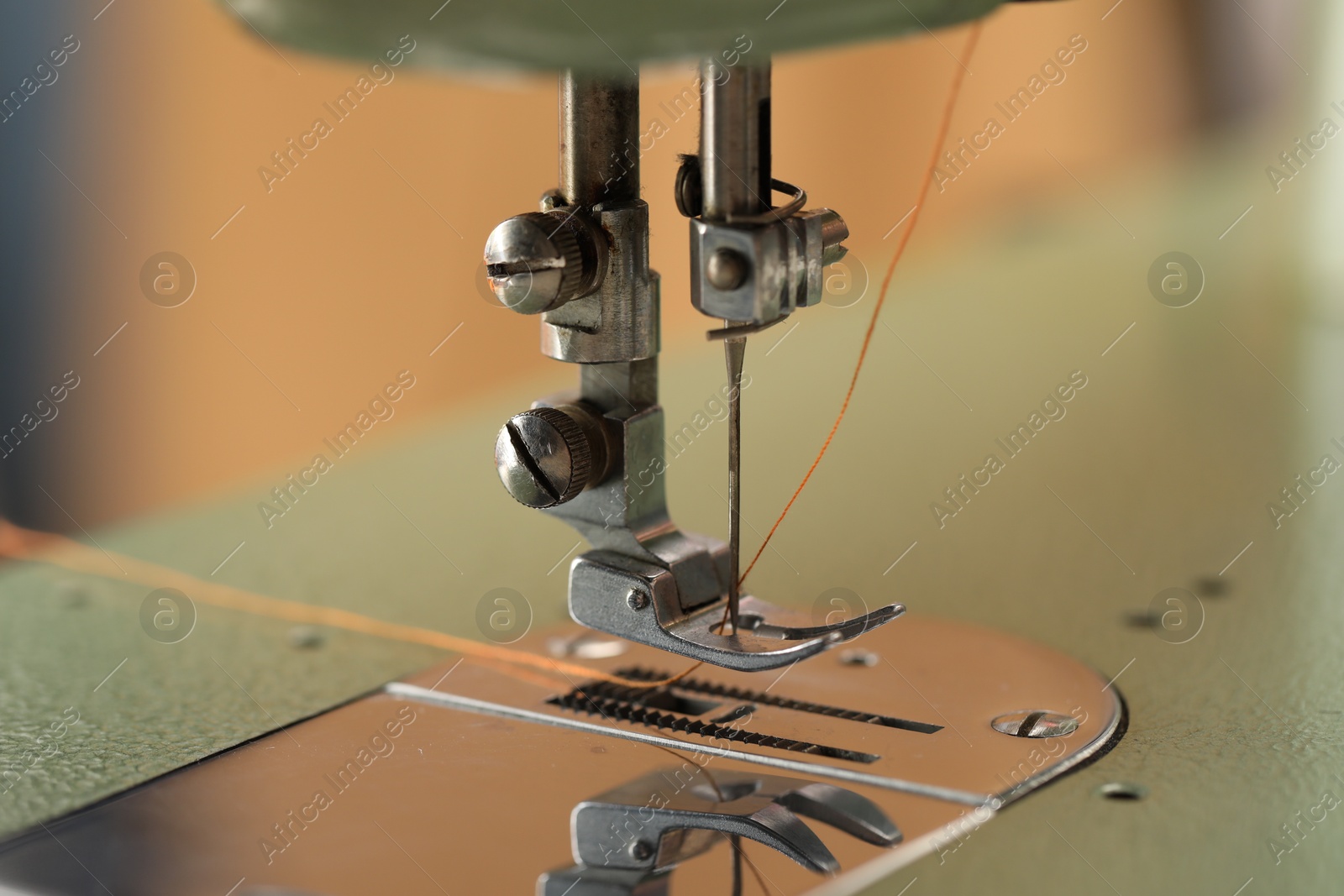 Photo of Vintage sewing machine with thread on blurred background, macro view