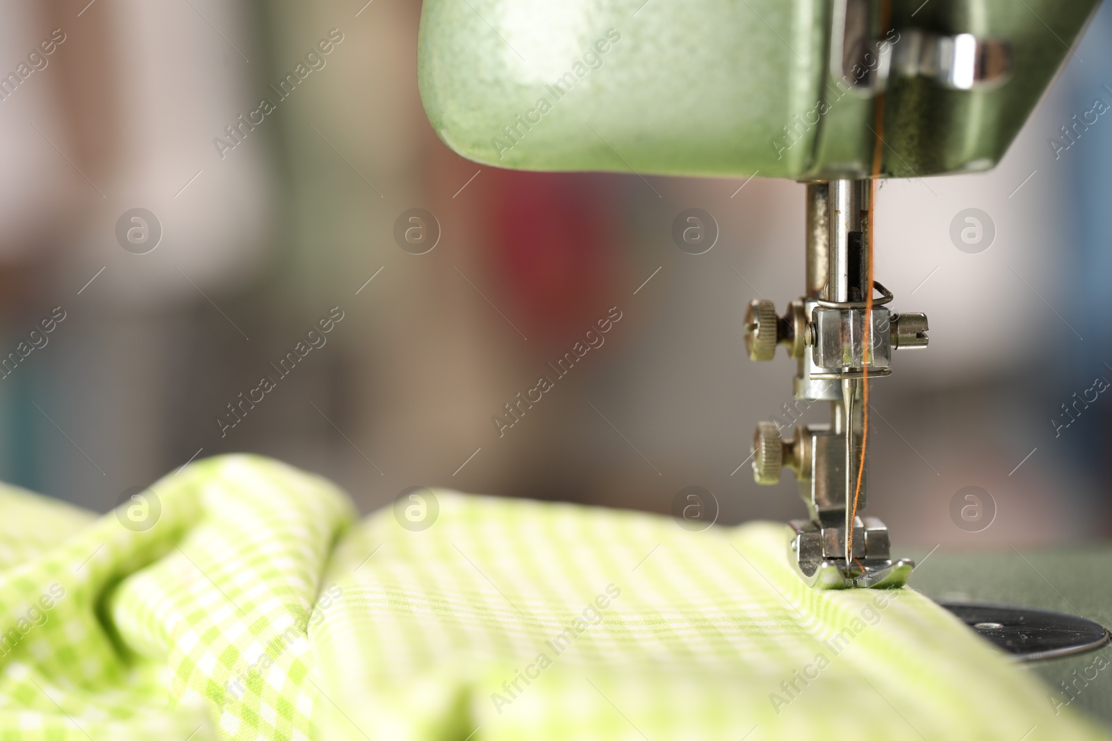 Photo of Vintage sewing machine with thread and fabric on blurred background, macro view. Space for text