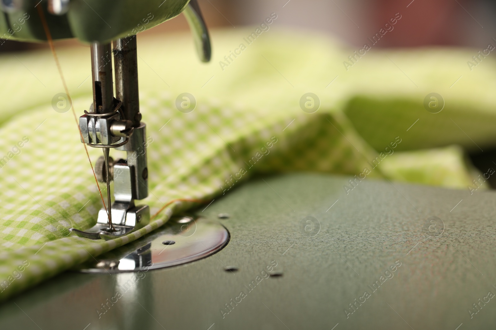 Photo of Vintage sewing machine with thread and fabric, macro view. Space for text