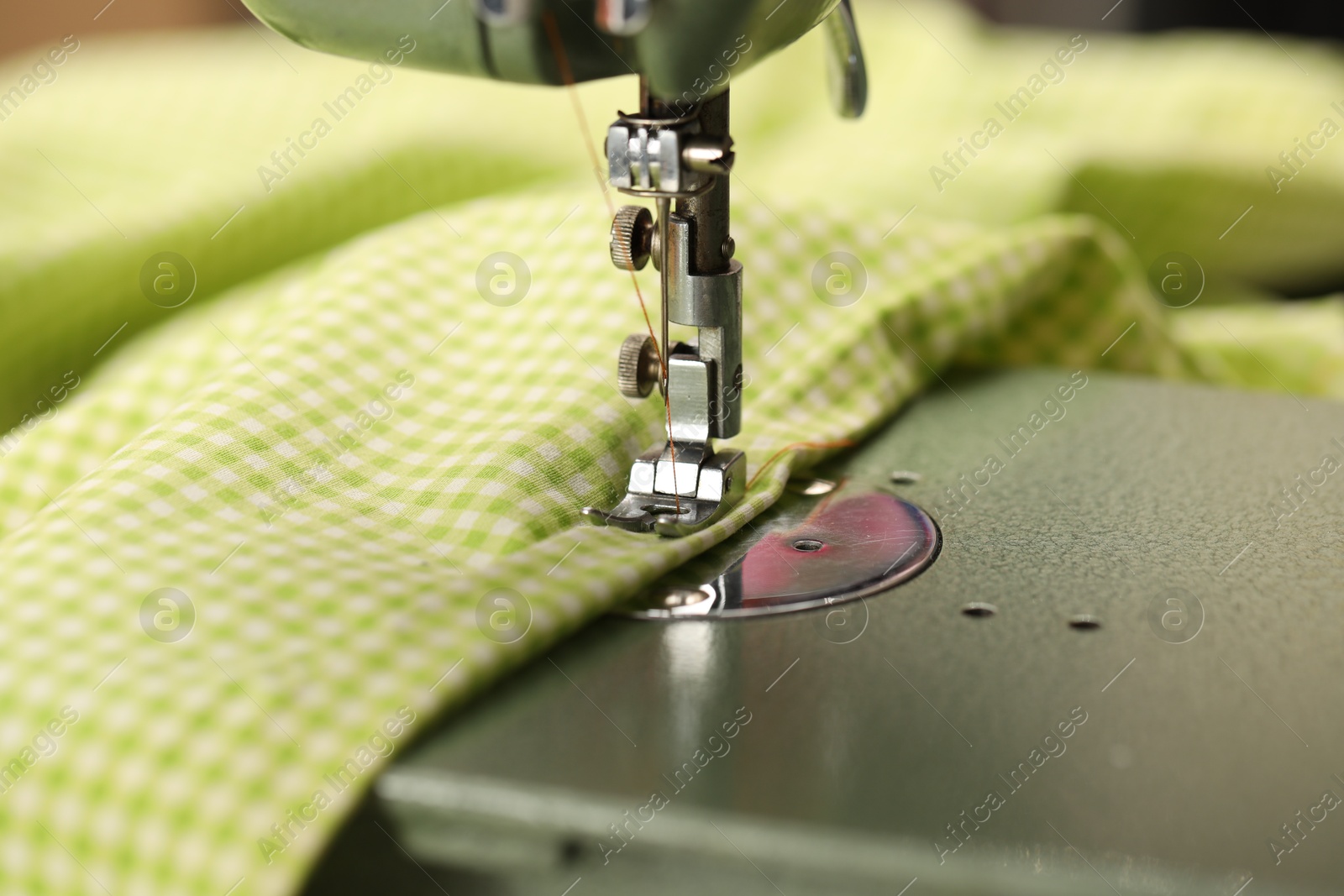 Photo of One sewing machine with thread and fabric, macro view