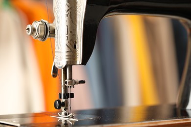 Photo of Vintage sewing machine with thread on blurred background, macro view