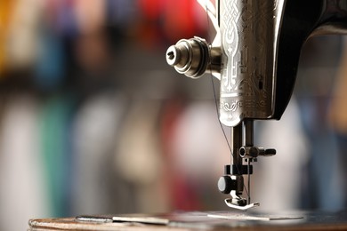 Photo of Vintage sewing machine with thread on blurred background, macro view. Space for text