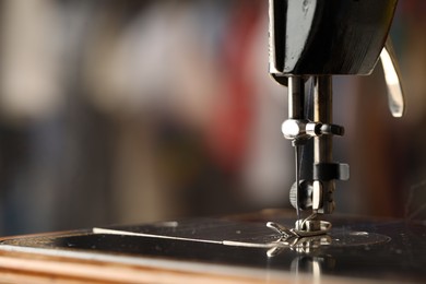 Photo of Sewing machine with thread on blurred background, macro view. Space for text