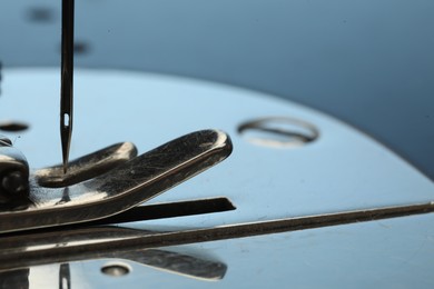 Photo of Sewing machine on light blue background, macro view. Space for text