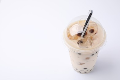 Photo of Tasty milk bubble tea in plastic cup on white background, space for text