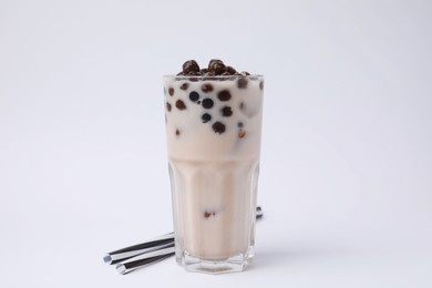 Photo of Tasty milk bubble tea in glass and straws on white background