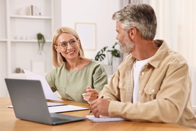 Photo of Pension savings. Couple planning budget at table indoors