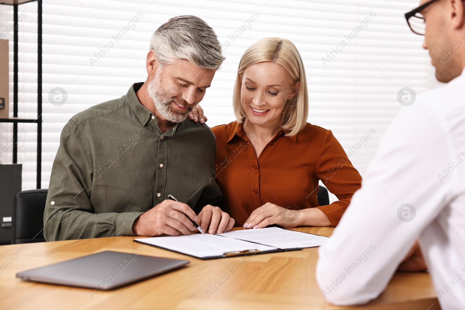 Photo of Pension plan. Couple consulting with insurance agent at table indoors