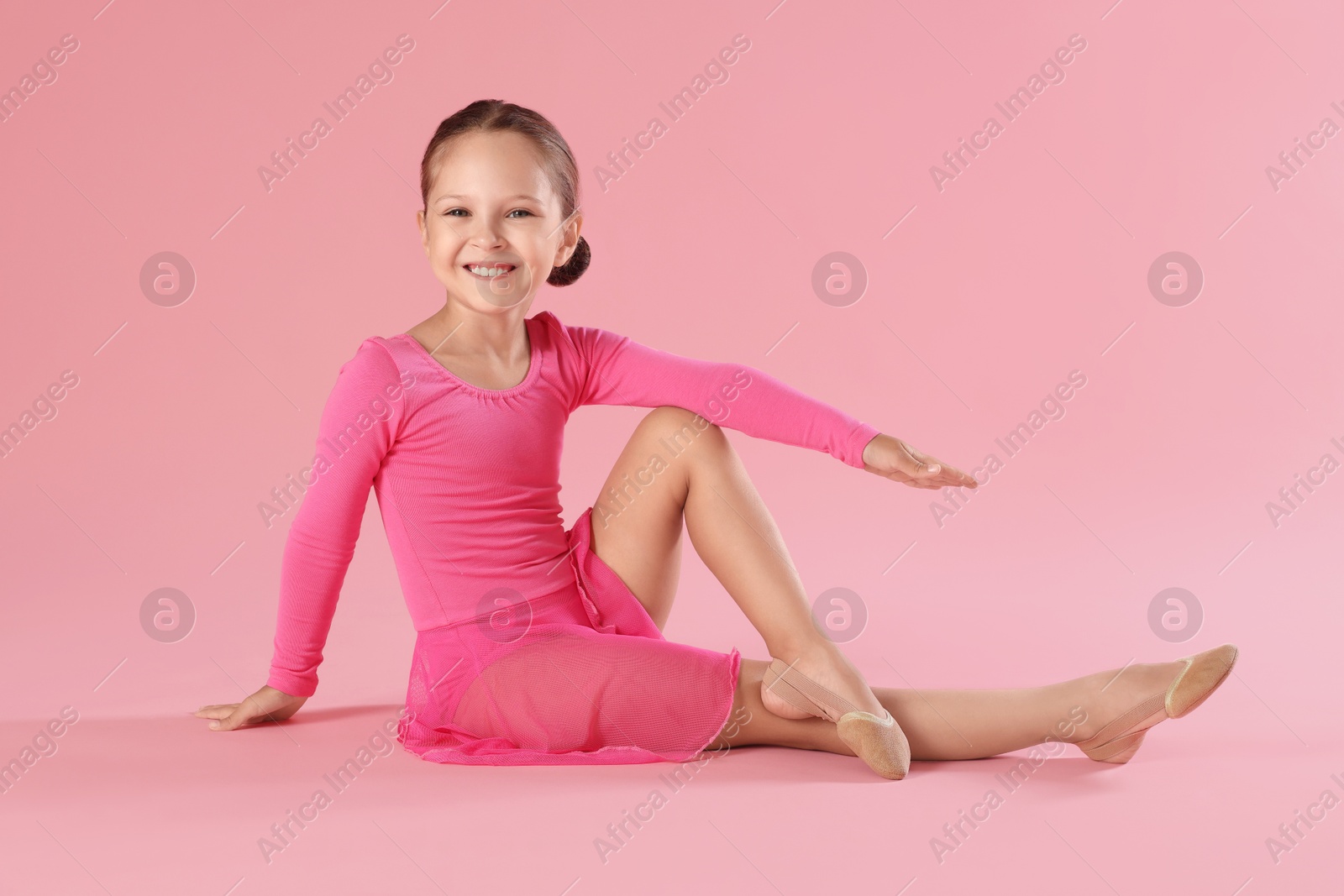 Photo of Portrait of little ballerina on pink background