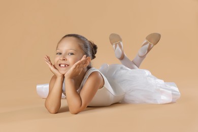 Portrait of little ballerina on beige background