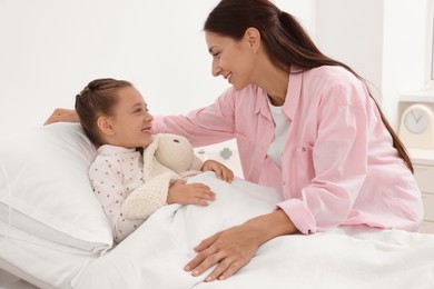 Mother and her little daughter on bed in hospital