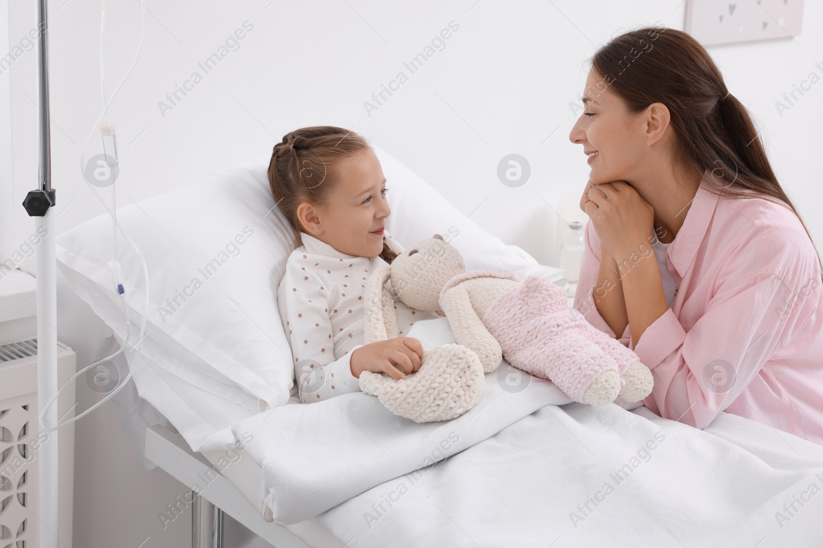 Photo of Mother and her little daughter on bed in hospital