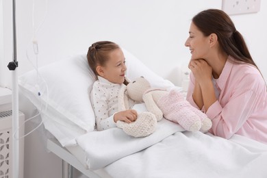 Photo of Mother and her little daughter on bed in hospital