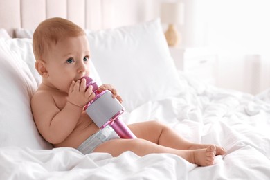 Cute little baby with microphone on bed at home, space for text