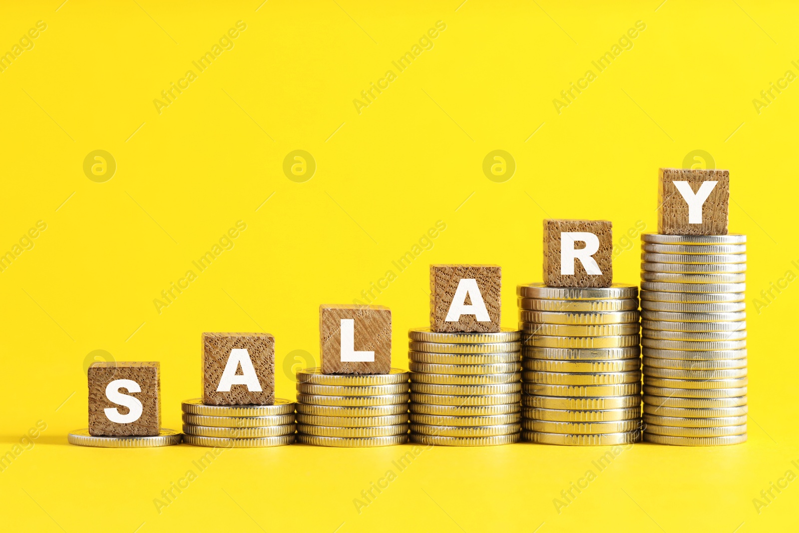 Photo of Blank wooden cubes and stacked coins on yellow background