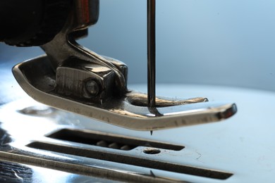 Photo of Sewing machine on light blue background, macro view