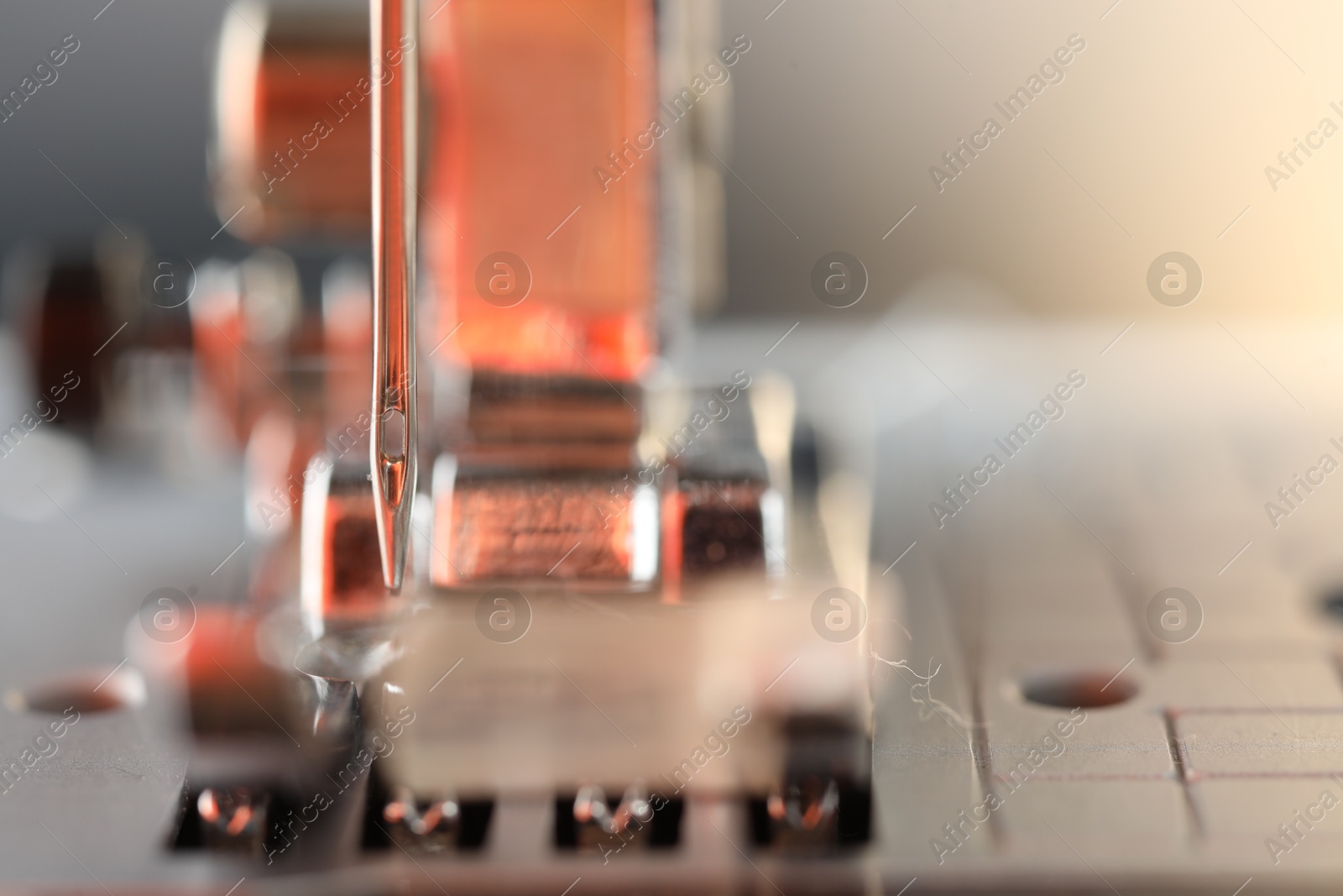 Photo of Sewing machine on light background, macro view. Space for text