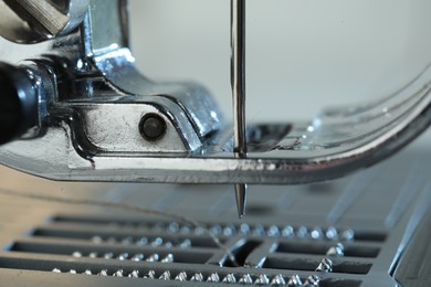 Photo of Sewing machine on light grey background, macro view