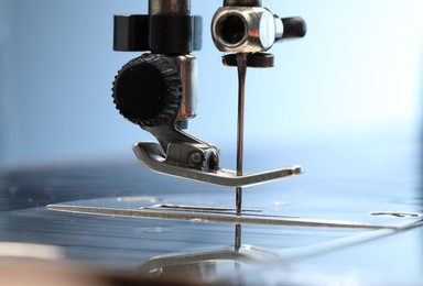 Photo of Sewing machine on light blue background, macro view