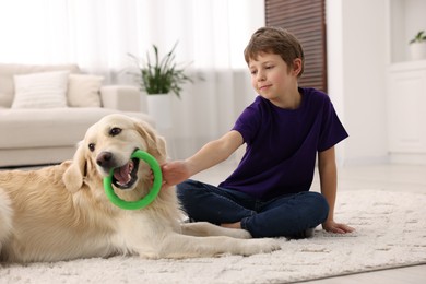 Photo of Boy playing with his cute dog at home