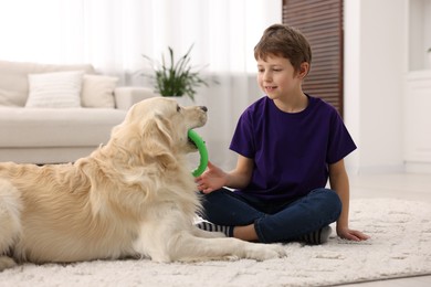 Photo of Boy playing with his cute dog at home