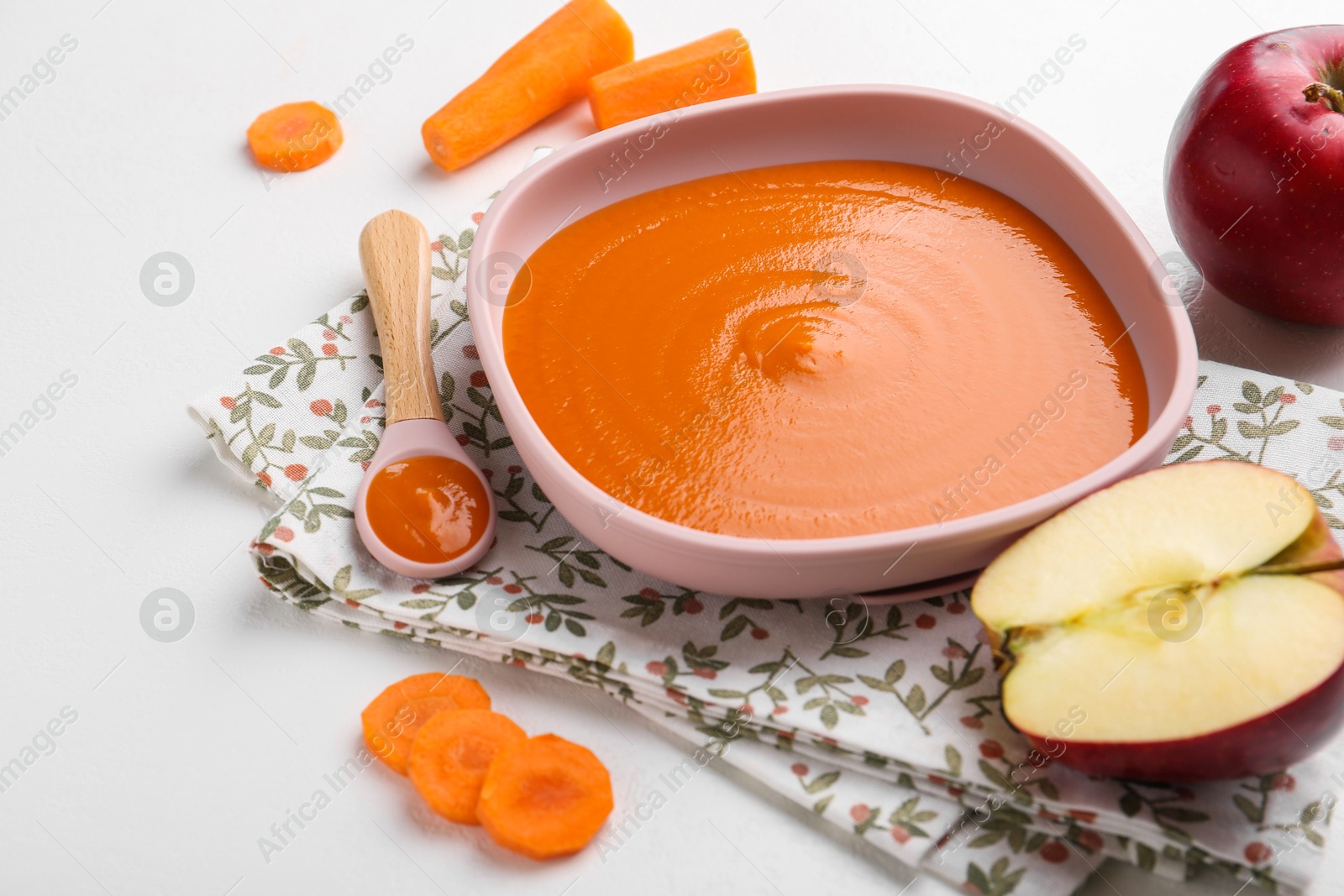 Photo of Delicious baby food in bowl and ingredients on white table