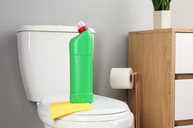 Photo of Detergent and rag on clean toilet in bathroom