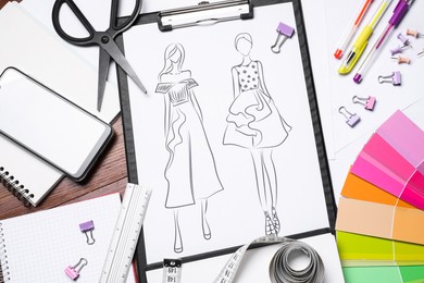 Photo of Sketch of stylish clothes and other fashion designer`s supplies on wooden table, flat lay