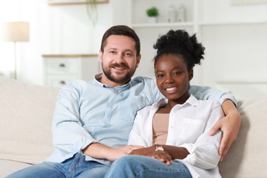 Photo of International relationships. Portrait of lovely couple on sofa at home