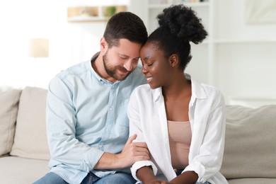 Photo of International relationships. Portrait of lovely couple on sofa at home