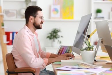 Photo of Designer working with computer at table in office