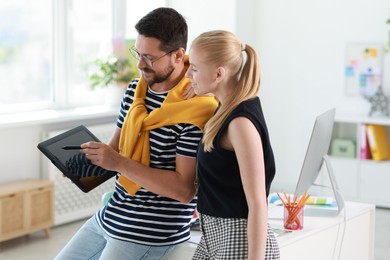 Photo of Designers with tablet working together in office