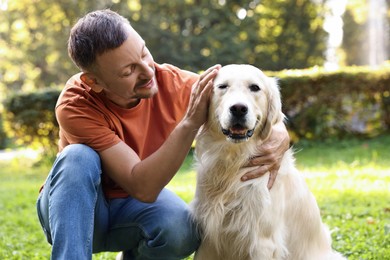 Photo of Man with cute Golden Retriever dog on spring day