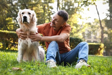 Photo of Smiling man with cute Golden Retriever dog on spring day