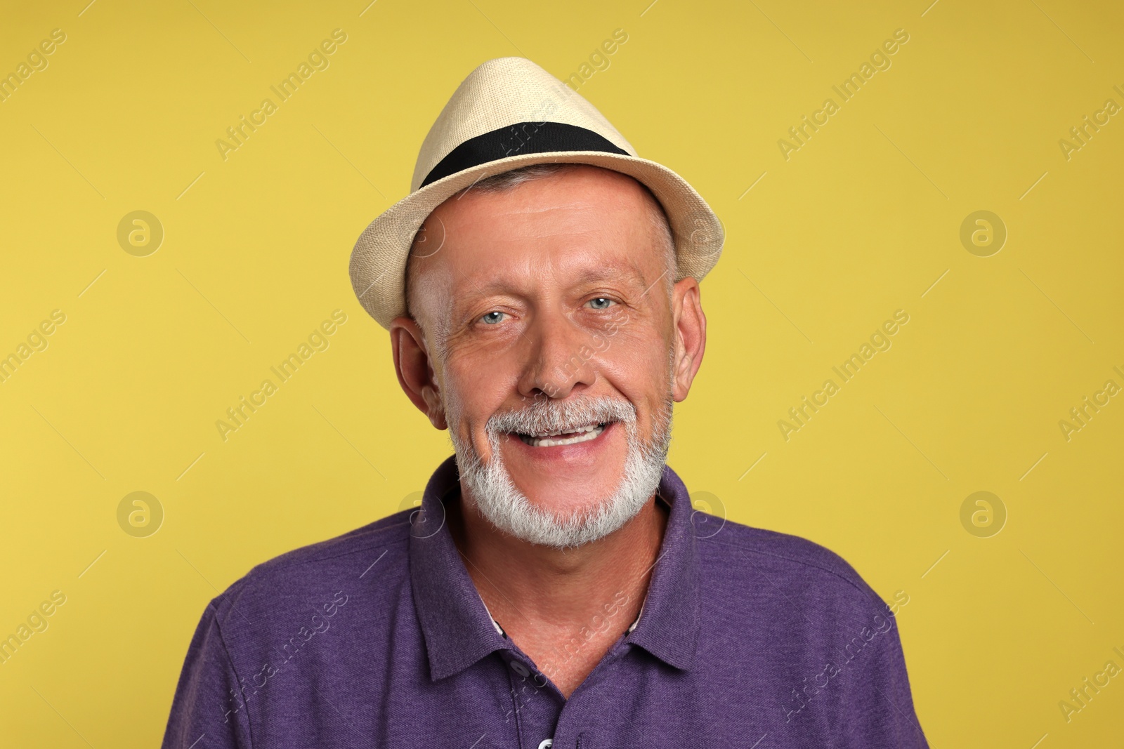 Photo of Portrait of happy senior man on yellow background