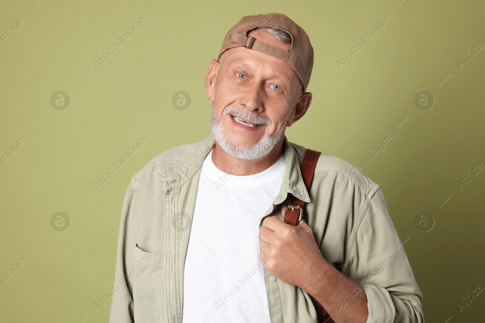 Photo of Portrait of happy senior man with backpack on green background