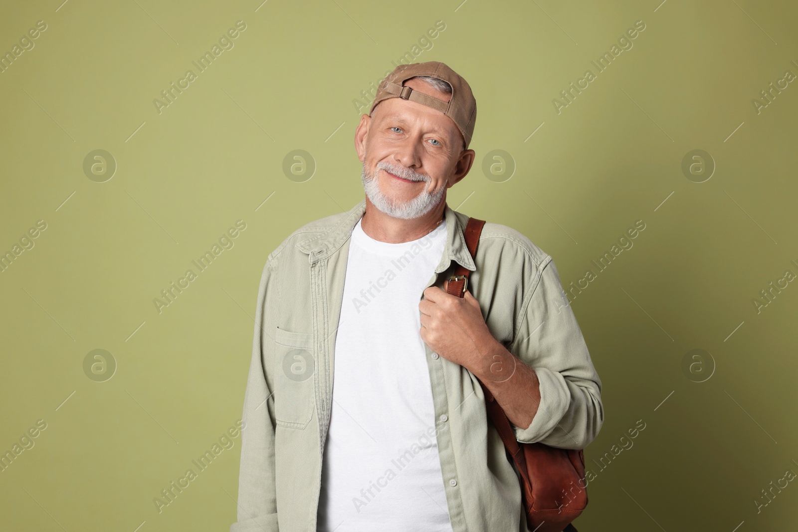 Photo of Portrait of handsome senior man with backpack on green background