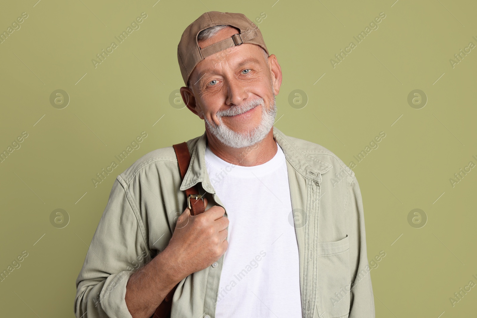 Photo of Portrait of handsome senior man with backpack on green background