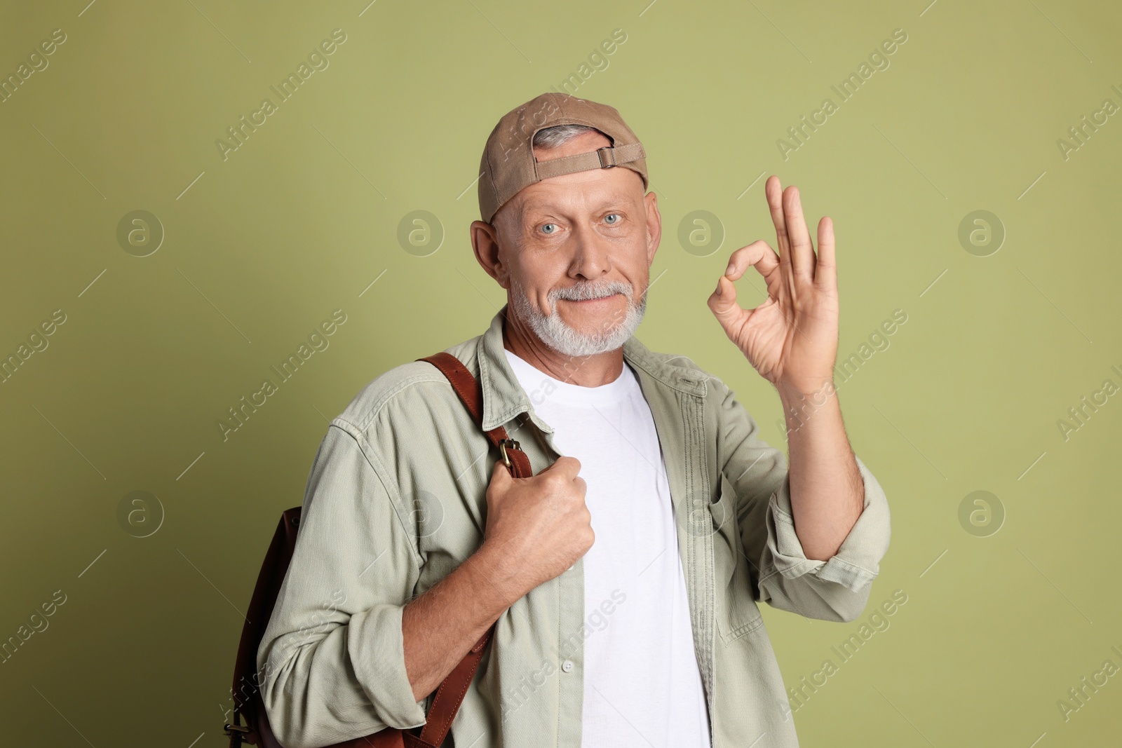 Photo of Portrait of senior man showing ok gesture on green background