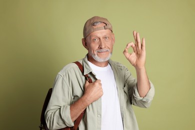 Photo of Portrait of senior man showing ok gesture on green background