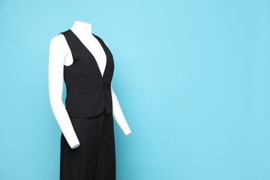 Photo of Female mannequin with stylish outfit on light blue background, space for text