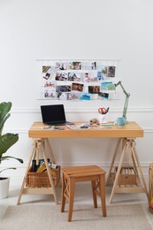 Stylish room interior with stool, table and vision board