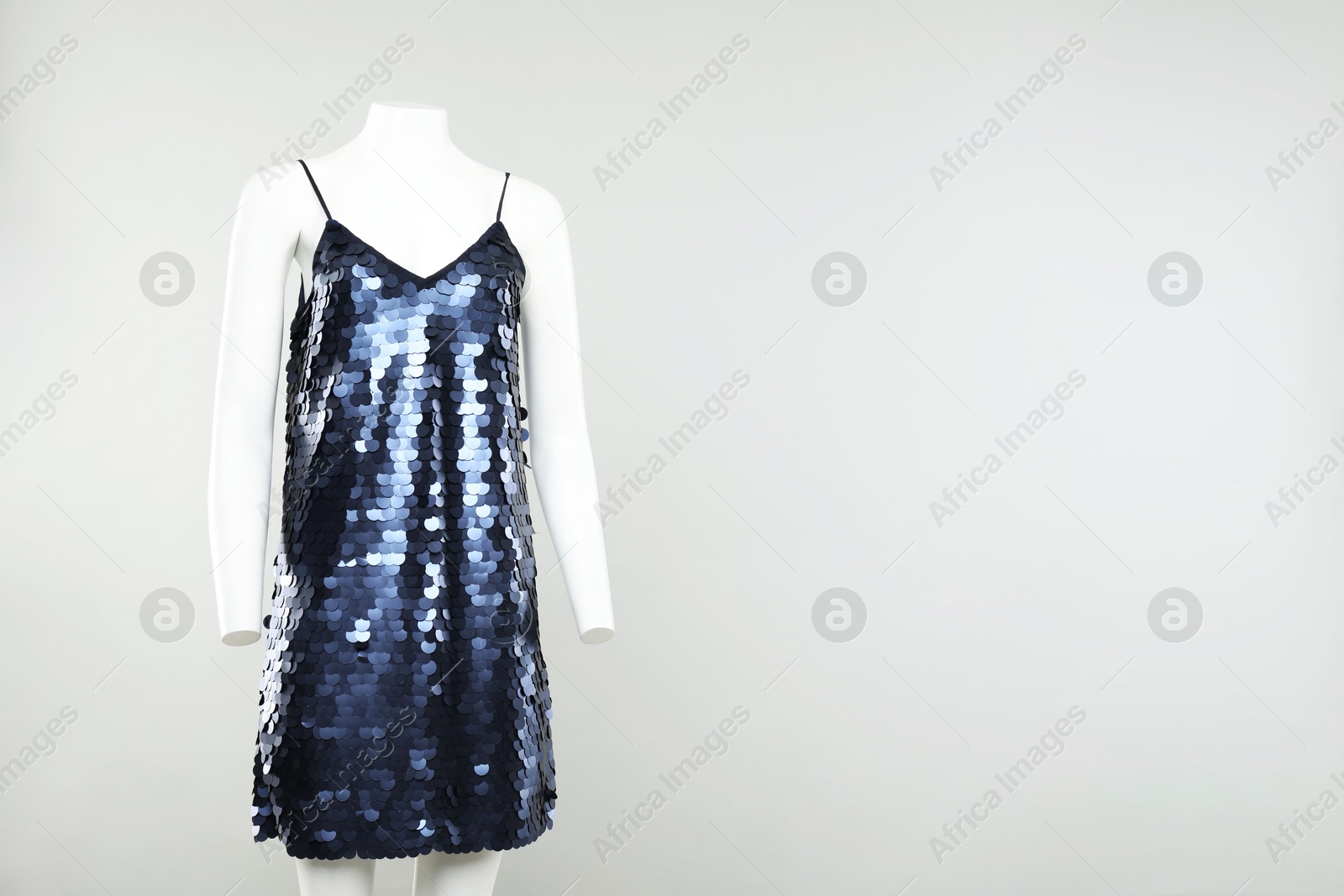 Photo of Female mannequin with stylish blue dress on light background, space for text