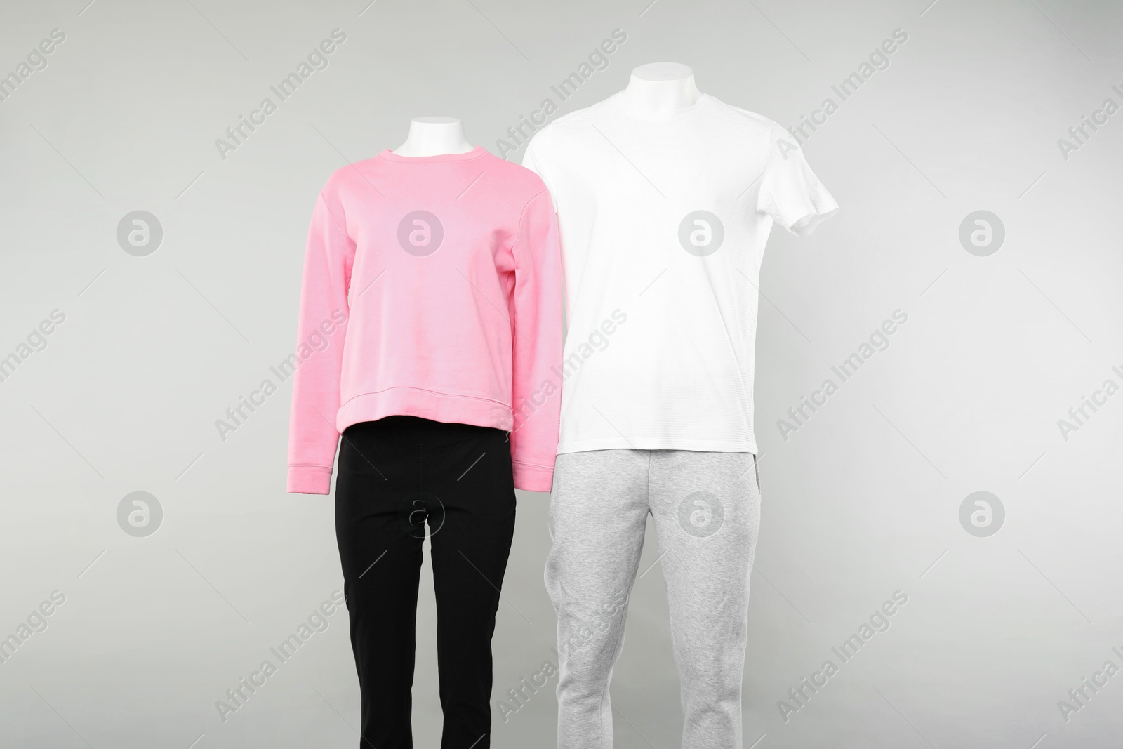 Photo of Female and male mannequins with stylish outfits on light background