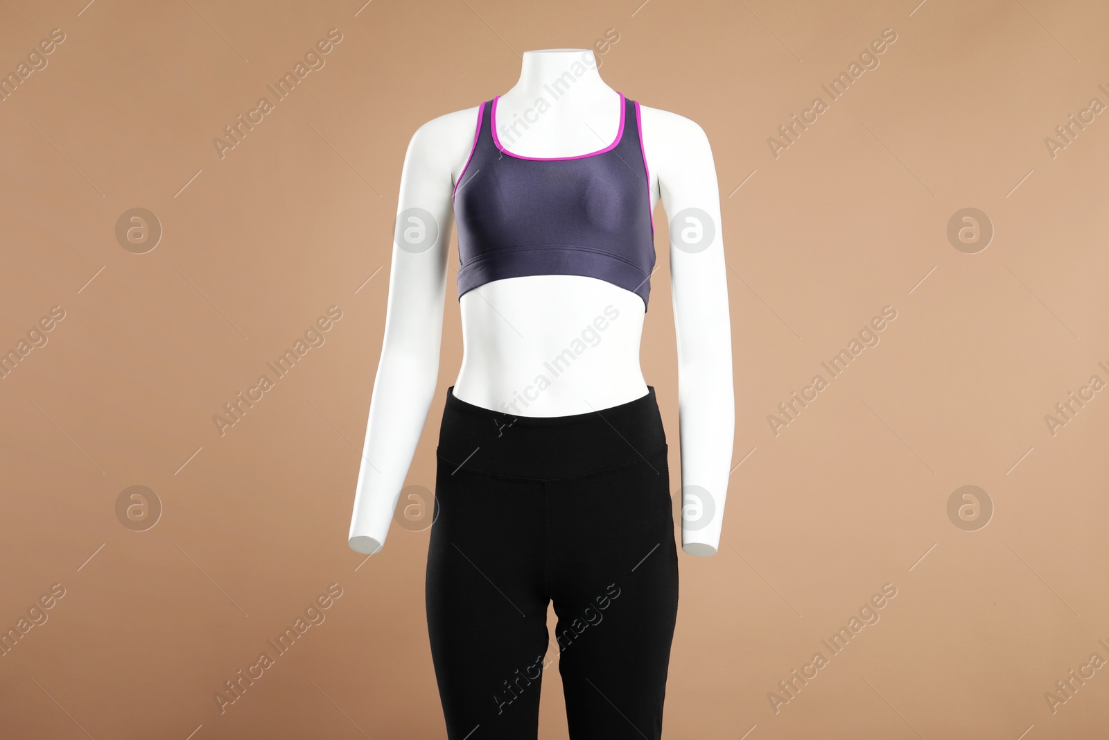 Photo of Female mannequin with stylish sportswear on beige background, space for text