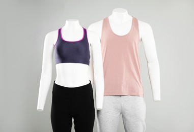 Photo of Female and male mannequins with stylish sportswear on light background