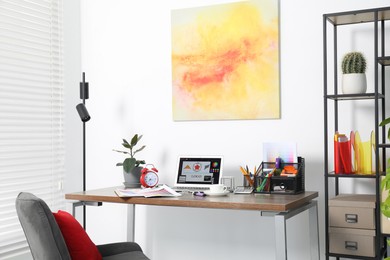 Photo of Fashion designer`s workplace with laptop and different supplies on table