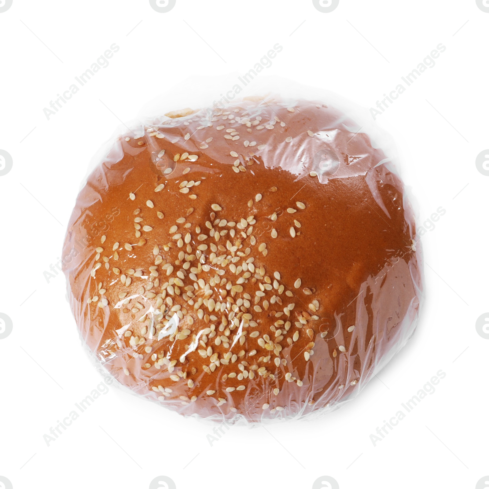 Photo of Fresh bun with plastic food wrap isolated on white, top view